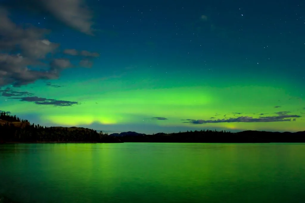 yukon lago laberge reflejo aurora boreal Canadá